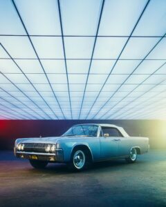 A vintage classic car displayed indoors with modern lighting, showcasing style and elegance.